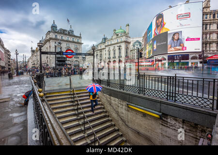 London, England - 15.03.2018: Turist Holding britischen Regenschirm und hinunter zum Piccadilly U-Bahn Station Stockfoto