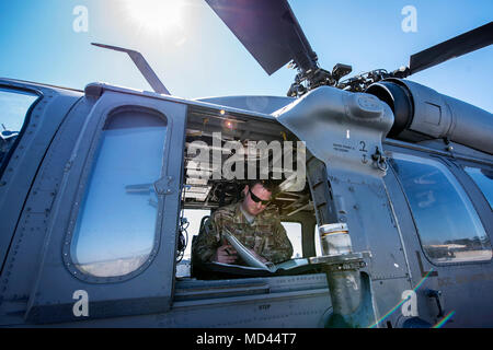 Tech. Sgt. Joshua Poe, 41 Rescue Squadron (RQS) spezielle Missionen aviator, liest einen Flugplan, 15. März 2018, bei Moody Air Force Base, Ga Flieger vom 41. RQS und 723 d Aircraft Maintenance Squadron durchgeführt vor, um zu gewährleisten, dass ein HH-60G Pave Hawk war voll für eine simulierte Suche und Rettung Mission vorbereitet. (U.S. Air Force Foto von Airman Eugene Oliver) Stockfoto