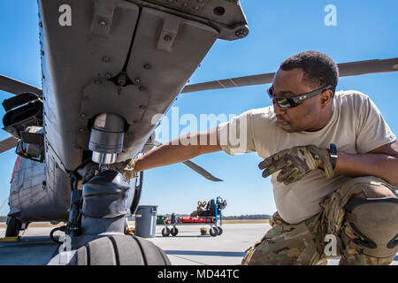 Senior Airman Latrell Salomo, 41. Rescue Squadron (RQS) spezielle Missionen aviator, inspiziert das Fahrwerk eines HH-60G Pave Hawk, 15. März 2018, bei Moody Air Force Base, Ga Flieger vom 41. RQS und 723 d Aircraft Maintenance Squadron durchgeführt vor, um zu gewährleisten, dass ein HH-60G Pave Hawk war voll für eine simulierte Suche und Rettung Mission vorbereitet. (U.S. Air Force Foto von Airman Eugene Oliver) Stockfoto