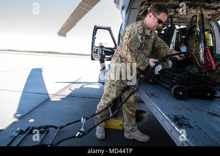 Tech Sgt. Joshua Poe, 41 Rescue Squadron (RQS) spezielle Missionen aviator, Orte eine Strickleiter auf ein HH-60G Pave Hawk, 15. März 2018, bei Moody Air Force Base, Ga Flieger vom 41. RQS und 723 d Aircraft Maintenance Squadron durchgeführt vor, um zu gewährleisten, dass ein HH-60G Pave Hawk war voll für eine simulierte Suche und Rettung Mission vorbereitet. (U.S. Air Force Foto von Airman Eugene Oliver) Stockfoto