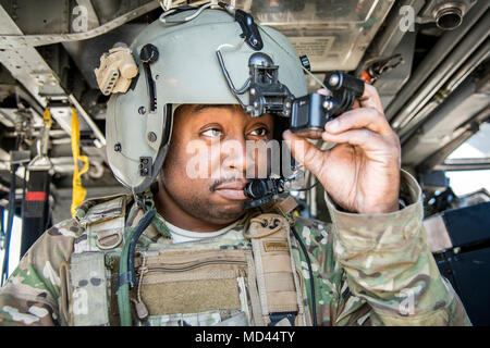 Senior Airman Latrell Salomo, 41. Rescue Squadron (RQS) spezielle Missionen aviator, inspiziert seine persönlichen Helm Kamera, 15. März 2018, bei Moody Air Force, Ga Flieger vom 41. RQS und 723 d Aircraft Maintenance Squadron durchgeführt vor, um zu gewährleisten, dass ein HH-60G Pave Hawk war voll für eine simulierte Suche und Rettung Mission vorbereitet. (U.S. Air Force Foto von Airman Eugene Oliver) Stockfoto