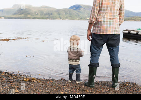 Kind und Vater auf der fjord Wasser Rand heraus suchen, Aure, Mehr og Romsdal, Norwegen Stockfoto