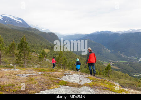 Mann mit Kindern wandern in der Berglandschaft, Rückansicht, Jotunheimen Nationalpark, Lom, Oppland, Norwegen Stockfoto