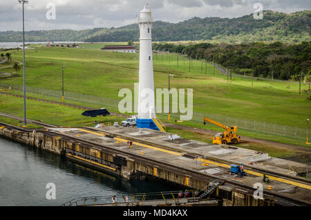 Wartungsarbeiten an den Schleusen in Gatun mit dem Leuchtturm im Hintergrund in Panama Stockfoto