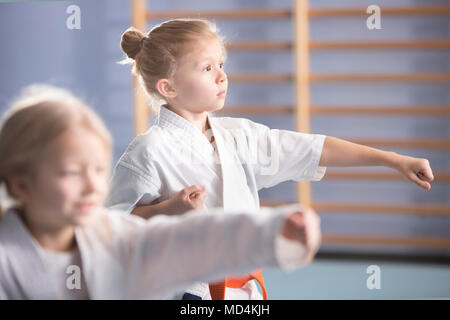 Junge Mädchen im Kimono trainieren während ein extra-curriculares Karate Klasse Stockfoto