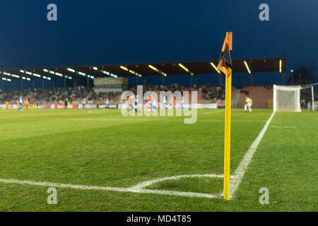 Fahne am Fußballplatz, im Hintergrund die Spieler in Aktion. Stockfoto