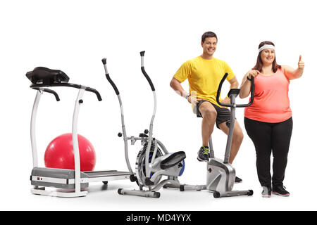 Junger Mann und eine übergewichtige Frau mit Trainingsgeräten auf weißem Hintergrund Stockfoto