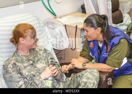 Israelische Cpt. Dana Reut, eine medizinische Assistentin der Yakar, Soroka Medical Center komfort Sgt zugeordnet. Shanda Owens, ein Patriot Fire Control Enhanced Operator/Betreuer zu Delta Batterie zugewiesen, 5 Battalion, 7th Air Defense Artillery, 10. Armee Luft- und Raketenabwehr Befehl nach einer gemeinsamen medizinischen Evakuierung (Medevac) Training Mission und medizinische Evakuierung während einer Juniper Cobra 18 in der Wüste Negev März 7, 2018. Stockfoto