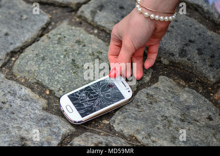 Person Kommissionierung gebrochen Smart Phone (Risse) der Boden Stockfoto