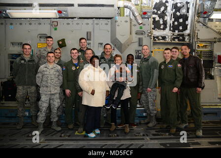 Eine Gruppe von Mitgliedern in Dover Air Force Base, Del zugewiesen und Holloman AFB, N.M., stand mit Kareem Bennett (Mitte) und seiner Familie auf dem Deck eines C-17 Globemaster III März 16, 2018, Dover AFB. Bennett war vom 3. Airlift Squadron eingeladen, in ihren ehrenamtlichen Pilot für einen Tag Programm, wo er sah einen Blick hinter die Kulissen Blick auf die Tag-zu-Tag Mission der Flieger von verschiedenen militärischen Karriere zu beteiligen. (U.S. Air Force Foto: Staff Sgt. Aaron J. Jenne) Stockfoto