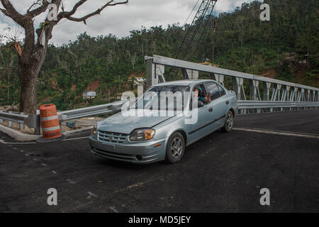 Utuado, Puerto Rico, März 13, 2018 -- Eine glückliche Bewohner von Río Abajo grüßt nach Überquerung der neuen Brücke in seiner Gemeinschaft. Nach dem Hurrikan María durch die Insel Riss, der starke Regen brach die bisherige Brücke verlassen mehr als 25 Familien isoliert. Heute, dank der Anstrengungen der örtlichen, Landes- und Bundesbehörden, hat die Gemeinschaft eine neue Brücke. Die FEMA/Eduardo Martínez Stockfoto