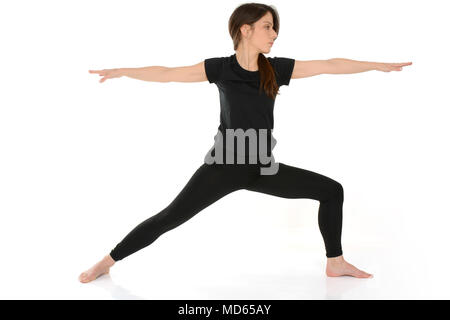 Junge Frau Yoga Asana Virabhadrasana Warrior Pose isoliert auf weißem Hintergrund Stockfoto