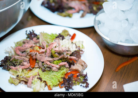 Warmer Salat mit Rindfleisch Warmer Salat mit Rindfleisch auf den Tisch an der Rezeption Stockfoto