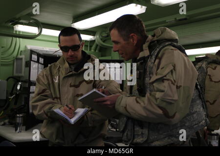 Chief Warrant Officer 3 Luis Castillo, ein multi-Klasse Commodity Manager mit der 364 Expeditionary Sustainment Command, und Chief Warrant Officer 3 Darin, Transport und Mobilität Chief mit dem 364 th, Überprüfen der Notizen zu springen Tactical Operations Center Coyote in Fort Knox, Ky., 22. März 2018, während der Kombinierten Situationstraining Übung - Brücke. Der Sprung TOC-Fähigkeit der 364 ESC demonstriert sustainment Operationen von einem mobilen Umgebung durchführen. Stockfoto