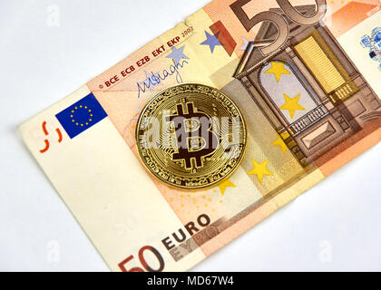 MONTREAL, KANADA - 10. MÄRZ 2018: Bitcoin cryptocurrency gold coin und Logo auf 50 Euro Bank Note. Stockfoto