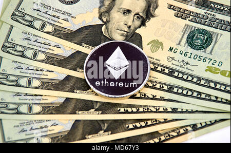 MONTREAL, KANADA - 10. MÄRZ 2018: astraleums cryptocurrency Silber münze und Logo auf amerikanischen Dollar Banknoten. Stockfoto