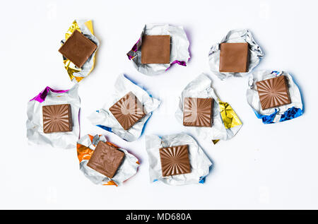 Schokolade in Stücke Alufolie auf weißem Hintergrund Stockfoto