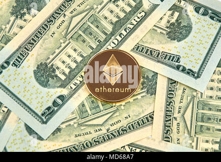 MONTREAL, KANADA - 10. MÄRZ 2018: astraleums cryptocurrency gold coin und Logo auf amerikanischen Dollar Banknoten. Stockfoto