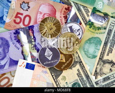 MONTREAL, KANADA - 10. MÄRZ 2018: Cryptocurrency Münzen auf kanadischen, amerikanischen und Euro-banknoten, litecoin, bitcoin, des Astraleums Stockfoto
