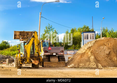 Traktor mit Schaufel führt Erdarbeiten. Bau der Umgehungsstraße um Krassnoje Selo, Sankt Petersburg. Schwere Maschinen fo Stockfoto