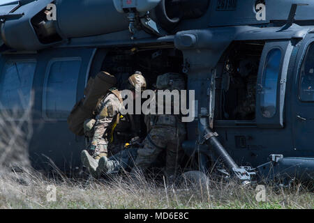 Pararescuemen vom 58th Rescue Squadron, Nellis Air Force Base, Nev, einem simulierten Unfall auf ein HH-60G Pave Hawk Last während Tiger Rescue IV, 30. März 2018, auf der Vandenberg Air Force Base, Calif. Der 4-tägigen Übung Flieger aus mehreren rescue Staffeln herausgefordert wird und die Fähigkeiten des Personals Wiederherstellung Triade zusammen erfolgreich abzuschließen, Rettungseinsätze zu bringen und zu halten. Die drei Zweige des Personal recovery Triade sind die HC-130J, HH-60G und dem Guardian Angel Waffen System oder pararescuemen. (U.S. Air Force Foto von älteren Flieger Janiqua S. Robinson) Stockfoto