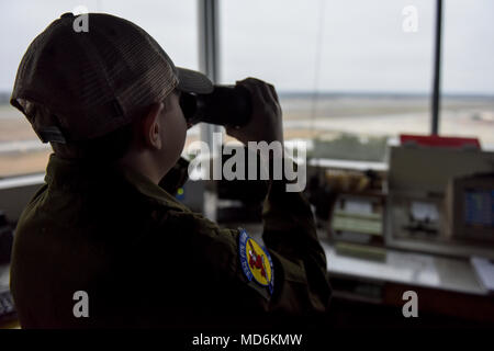 Dylan Bolles-Prasse verwendet ein Fernglas in der Ansicht von der Flugverkehrskontrolle zu nehmen, 12. März 2018, bei Seymour Johnson Air Force Base, North Carolina. Bolles-Prasse beobachtete mehrere F-15E Strike Eagles starten, bevor Sie sich in das Cockpit eines später am Tag zu sitzen. (U.S. Air Force Foto: Staff Sgt. Brittain Crolley) Stockfoto