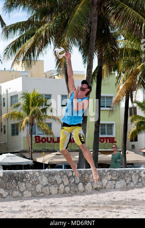 Ein Mann trifft einen starken Sprung in eine Abholung am Strand Volleyball an einem öffentlichen Strand aus Ocean Drive am 27. Dezember 2014 in Miami, FL dienen. Stockfoto