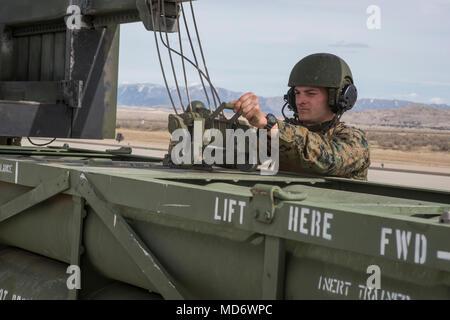 Marine Corps Sgt. Jeffery Hale, ein Launcher Chief mit Kilo. Akku, 2. Bataillon, 14 Marine Regiment, Haken Raketen pods an einem Kettenzug auf ein M142 High Mobility Artillery Rocket System (HIMARS) am Dugway Proving Grounds, Utah, 30. März 2018. Marines von Kilo Batterie flogen von Fort Campbell, Ky., Dugway, wo Sie entladen und feuerte vier HIMARS Raketen, die eine einzigartige Fähigkeit, die kommandeure mehr Optionen mit Bedrohungen zu begegnen, wenn die anderen Optionen nicht angemessen sind. (Marine Corps Foto von Lance Cpl. Niles Lee) Stockfoto