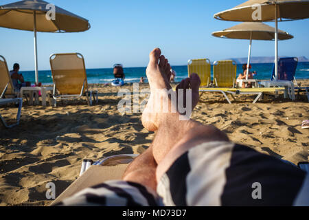 Niedrige Abschnitt der Barefoot mann Entspannung am Sandstrand Lounge Chair Stockfoto