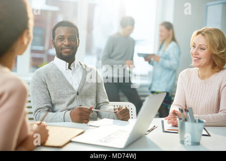 Multi-ethnischen Team von talentierten Designern versammelten sich im geräumigen Großraumbüro und Brainstorming auf ehrgeizige gemeinsame Projekt Stockfoto