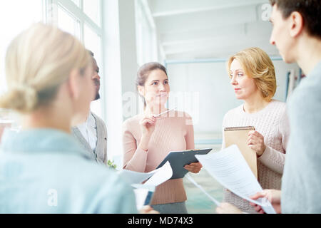 Kreative Gruppe von Designern zusammen an geräumige offene Büro gesammelt und Brainstorming über ehrgeizige Innenraum Projekt Stockfoto