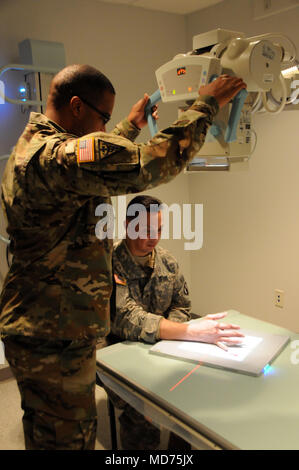 Staff Sgt. Perry Johnson, eine Radiologie Specialist 7417th Truppe Medizinische Klinik zugeordnet, prüft sein Patient, Sgt. Hector Santiago, ein petroleumversorgung Specialist zu 941St Quartermaster Co., 1. Mission unterstützt den Befehl zugeordnet, für Handverletzungen beim Training in Fort Knox, Kentucky. ARMEDCOM Soldaten zu 7231St medizinische Unterstützung und 7417Th Truppe Medizinische Klinik zugeordnet unterstützt medizinische Soldat Bereitschaft Verarbeitung und Truppe Medizinische Klinik Operationen während ihrer Ausbildung in Fort Knox, Kentucky auf März 1-15, 2018. Die erfolgreiche "Proof-of-Concept"-Programm wird von mehreren umgesetzt Stockfoto