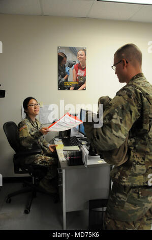 Spc. Jisung Kim, ein Healthcare Spezialist zugeordnet Der 7231st Medical Support Unit zu unterstützen, bietet ausgefüllten Formularen in die Immunisierung der Soldat Bereitschaft Verarbeitung SPC. Scott Gerber, Dusche/Wäsche und Kleidung Reparatur Specialist 855th Quartermaster Firma zugewiesen, 310Th Expeditionary Sustainment Command, 14. März 2018. ARMEDCOM Soldaten zu 7231St medizinische Unterstützung und 7417Th Truppe Medizinische Klinik zugeordnet unterstützt medizinische Soldat Bereitschaft Verarbeitung und Truppe Medizinische Klinik Operationen während ihrer Ausbildung in Fort Knox, Kentucky auf März 1-15, 2018. Die successf Stockfoto