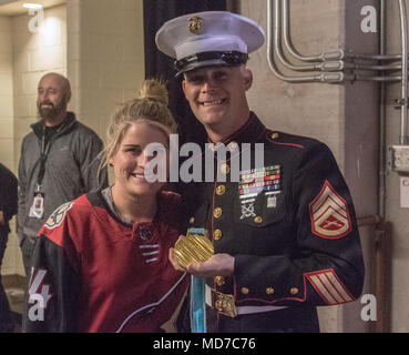 Staff Sgt. Sean Kaspar, ein Unteroffizier mit einziehenden Station Phoenix, wirft mit Brianna Decker, einem Mitglied der US-amerikanischen Frauen National Hockey Team, während einer Arizona Kojoten hockey Spiel auf März 31,2018 am Gila River Arena, Glendale, Ariz., AZ. Kaspar war der Service Mitglied des Spiels genannt. (U.S. Marine Corps Foto von Sgt. Alvin Pujols) Stockfoto