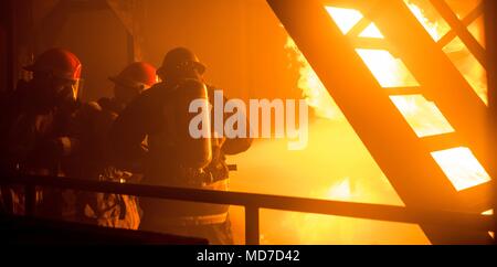 180403-N-ist 471-0232 Yokosuka, Japan (3. April 2018) Segler auf die marine Vorwärts - bereitgestellt Flugzeugträger USS Ronald Reagan (CVN 76) zugeordnet, die Bekämpfung einer simulierten Maschinenraum Feuer während der Ausbildung an der Yokosuka Brandbekämpfung und Beschädigung der Anlage. Ronald Reagan, das Flaggschiff der Carrier Strike Group 5, bietet eine Bekämpfung bereit, Kraft, schützt und verteidigt die kollektive maritime Interessen seiner Verbündeten und Partnern in der Indo-Asia-Pazifik-Region. (U.S. Marine Foto von Mass Communication Specialist 1. Klasse Glenn Schlachtung/Freigegeben) Stockfoto