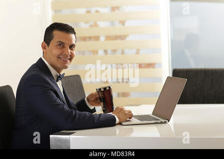 Stattliche bussines Männer arbeiten und lächelnd und Usind Geräte Stockfoto