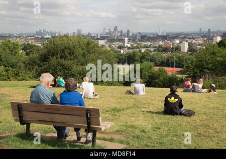 Menschen entspannen und den Panoramablick auf die Skyline von London an einem Sommernachmittag auf dem Parliament Hill in Hampstead Heath in Nord London genießen Stockfoto