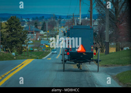 Blick auf die Rückseite eines altmodischen, Amish Buggy mit einem Reiten auf Schotter Landstraße Stockfoto