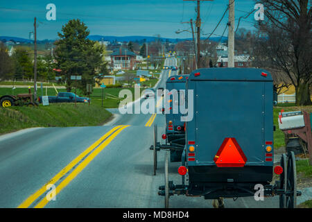 Pennsylvania, USA, April, 18, 2018: Blick auf die Rückseite eines altmodischen, Amish Buggy mit einem Reiten auf Schotter Landstraße Stockfoto