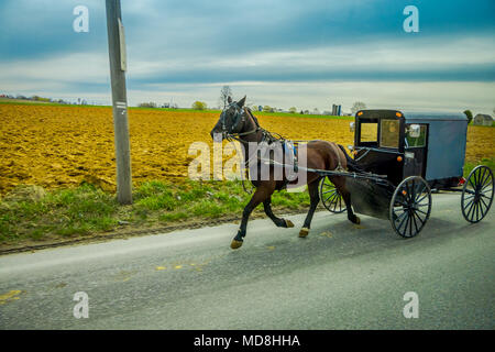 Ein Amish Pferd und Wagen fährt auf einer Landstraße in Lancaster County, Pennsylvania Stockfoto