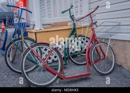 Pennsylvania, USA, April, 18, 2018: Outdoor Ansicht der Amish Roller Fahrräder oder Motorroller lean gegen ein Haus Stockfoto