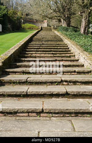 Yorkstone Schritte durch eine Mauer aus Stein in einem Garten in Kent Stockfoto