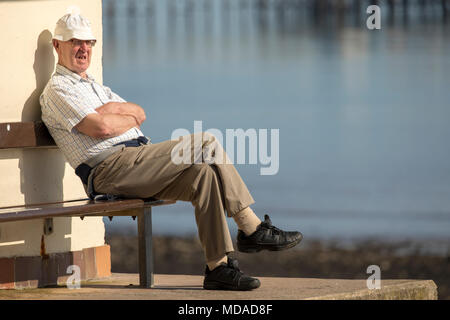 Ältere männliche allein saß auf der Werkbank Stockfoto