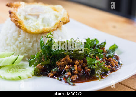 Reis garniert mit gebratenen Spiegelei und Schweinefleisch und Basilikum. Thai Food Stil. Stockfoto