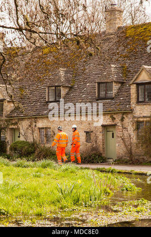 Handwerker in Orange Hi Vis Arbeit tragen außerhalb Arlington Row in der englischen Cotswold Village von Bibury Gloucestershire durch den National Trust England, Stockfoto