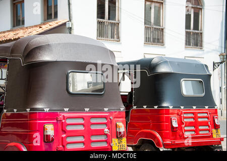 Ansicht der Rückseite des roten und schwarzen Tuktuk Taxis, in einem typischen Straßenbild, Galle, Sri Lanka Stockfoto