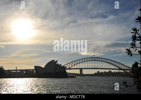 Skyline von Sydney mit Opernhaus und Harbour Bridge gegen die untergehende Sonne. Stockfoto