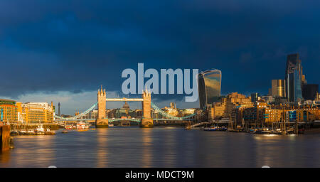 London, England - Schöne golden sunrise in London Tower Bridge, St. Paul's Kathedrale und den Wolkenkratzern der Bank District. Dramatische dunkle Wolken am Stockfoto