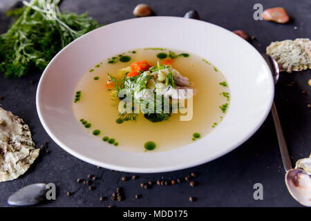 Seafood Suppe in einer weißen Platte auf einen konkreten Hintergrund Stockfoto