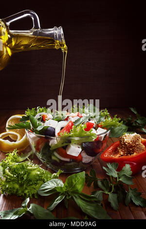 Griechischer Salat mit Olivenöl Ausgießen aus der Flasche und frischem Gemüse. Kopieren spase. Stockfoto